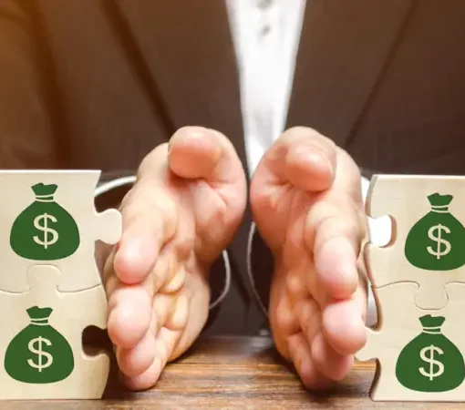 Mãos separando peças de quebra-cabeça com símbolos de dinheiro, representando divisão de bens.